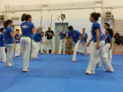 I giocatori di capoeira al centro eseguono un continuo movimento con le gambe, chiamata ginga